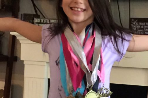 Grace with gymnastics medals from level 3